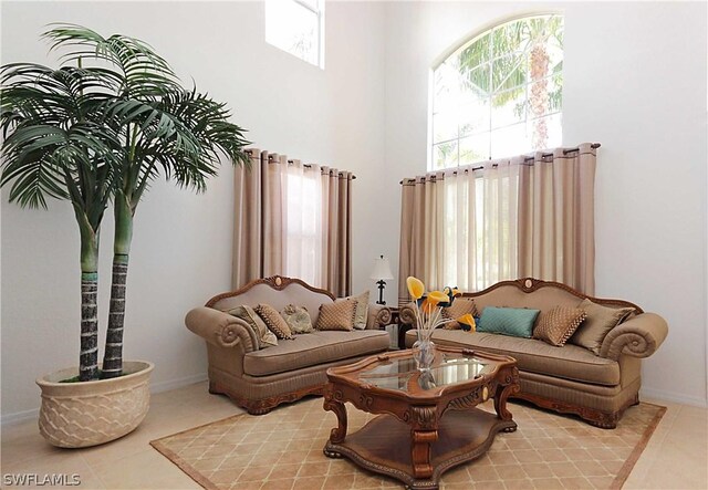 living room featuring a healthy amount of sunlight, a towering ceiling, and light tile patterned floors