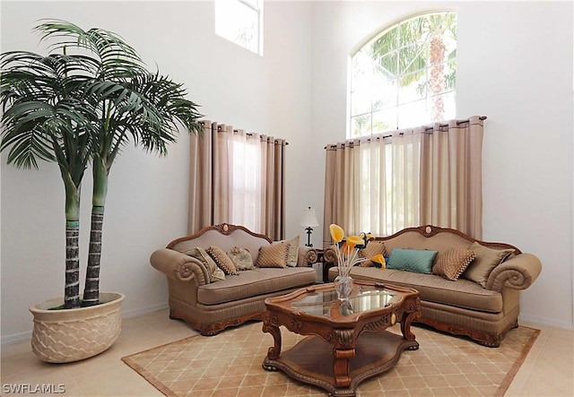 living room featuring light tile patterned floors and a towering ceiling