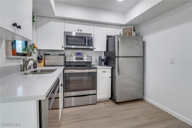 kitchen featuring white cabinetry, light hardwood / wood-style flooring, appliances with stainless steel finishes, and sink