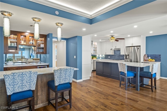 kitchen with white cabinets, appliances with stainless steel finishes, dark wood-type flooring, and a large island