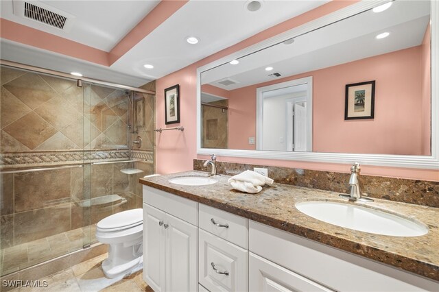 bathroom featuring toilet, vanity, and an enclosed shower