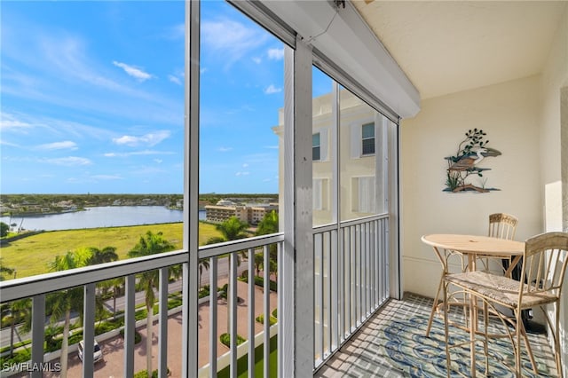 sunroom featuring a water view