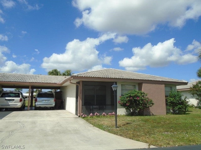 single story home with driveway, a tile roof, a front yard, a carport, and stucco siding