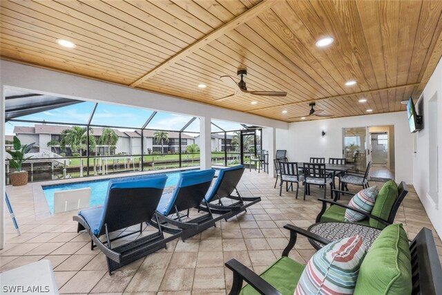 view of pool with ceiling fan, a patio area, and a lanai