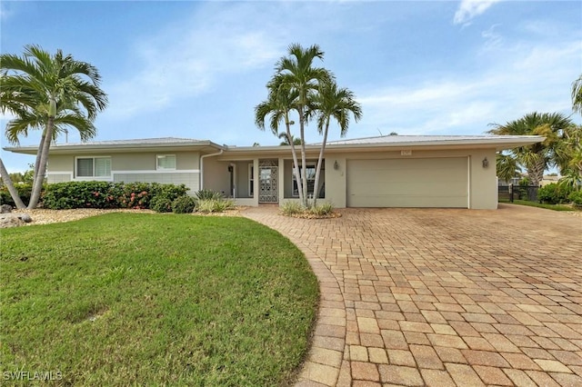 ranch-style house featuring a garage and a front lawn