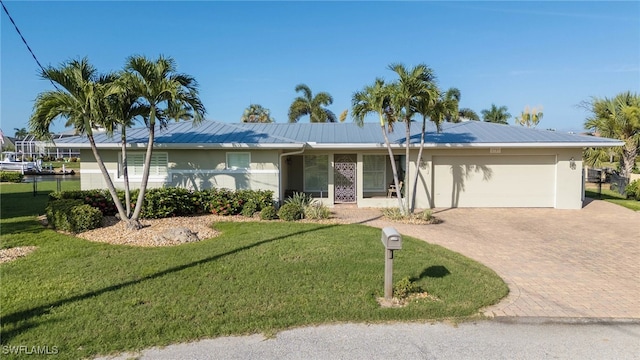 ranch-style home featuring a garage and a front lawn