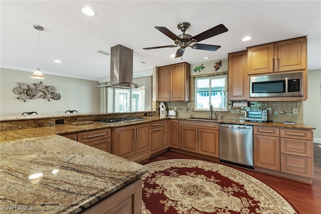 kitchen featuring dark hardwood / wood-style flooring, stone countertops, stainless steel appliances, island range hood, and decorative light fixtures