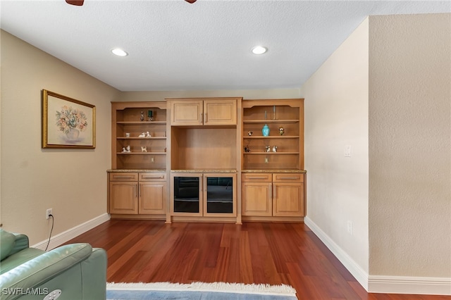 unfurnished living room with a textured ceiling and dark hardwood / wood-style floors