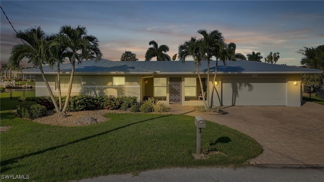 single story home with a yard and a garage