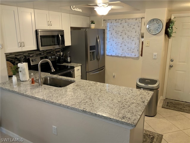 kitchen featuring light tile patterned floors, ceiling fan, stainless steel appliances, decorative backsplash, and sink