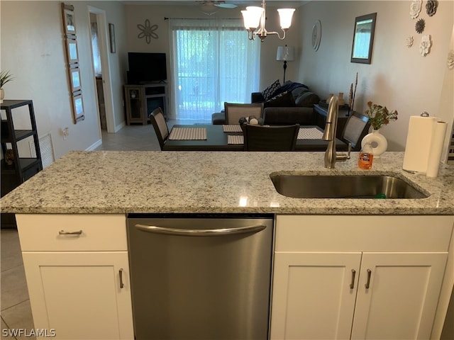 kitchen featuring sink, stainless steel dishwasher, light tile patterned floors, and light stone countertops