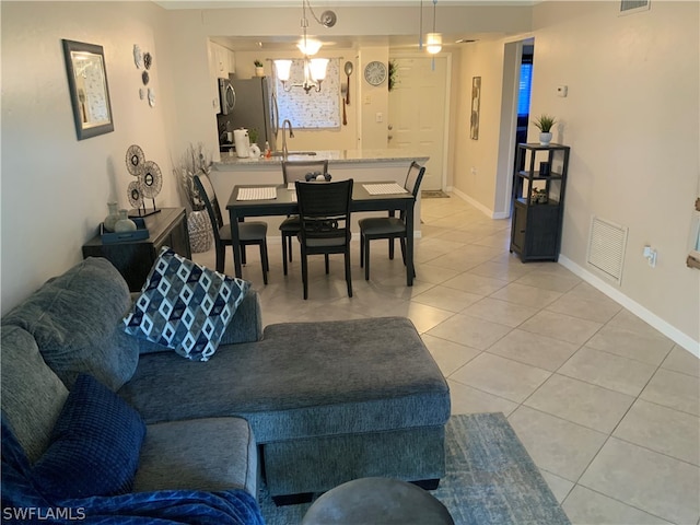 tiled living room with sink and a chandelier