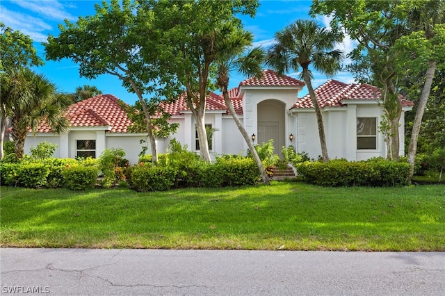 mediterranean / spanish home featuring a front yard