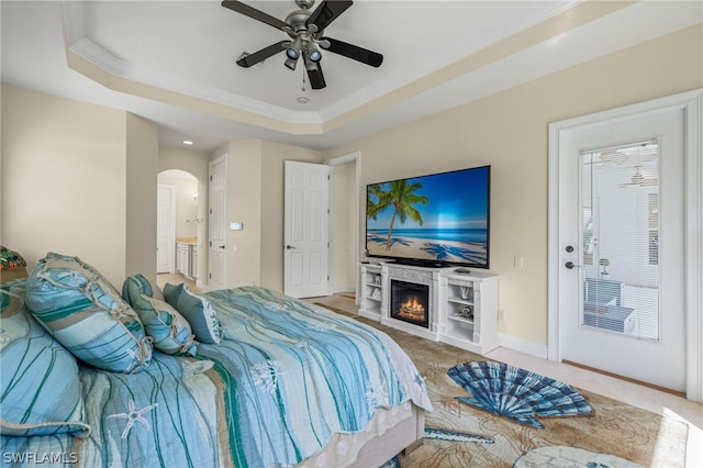 bedroom featuring connected bathroom, carpet flooring, ceiling fan, a raised ceiling, and crown molding