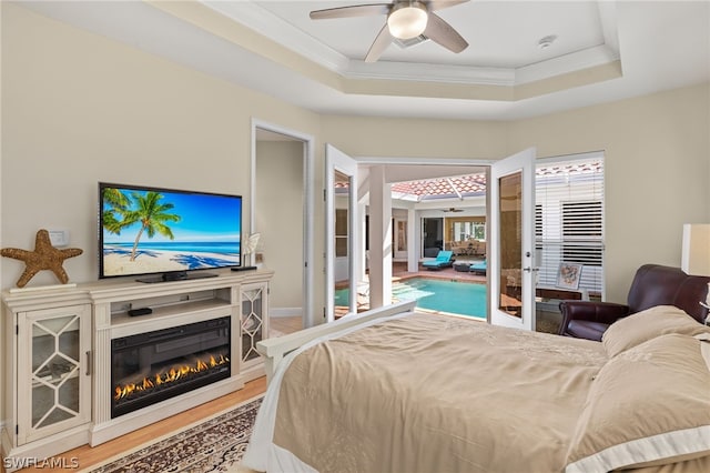 bedroom featuring crown molding, a tray ceiling, and hardwood / wood-style flooring