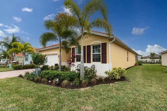 view of front of home with a garage and a front lawn