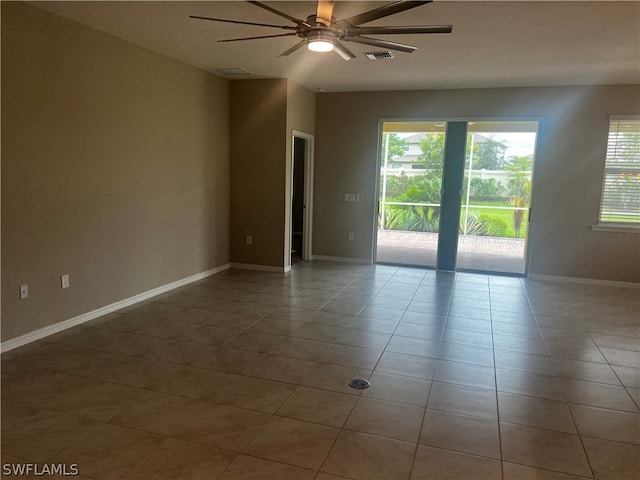 tiled empty room featuring ceiling fan and a healthy amount of sunlight