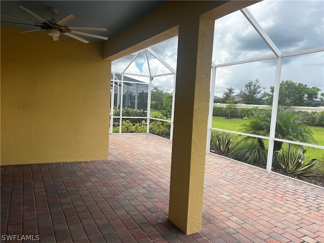 unfurnished sunroom featuring ceiling fan