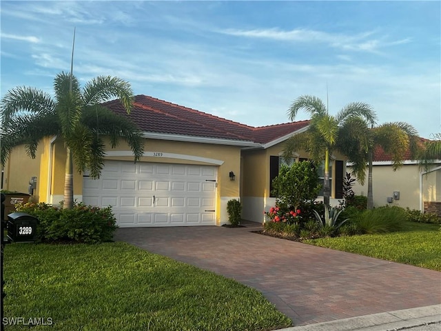 ranch-style home with a garage and a front lawn