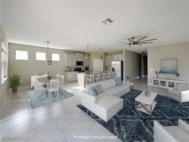 tiled living room with ceiling fan