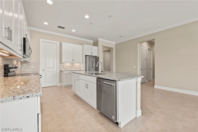 kitchen with tasteful backsplash, stainless steel appliances, a center island with sink, and white cabinets