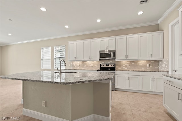 kitchen with appliances with stainless steel finishes, light tile patterned floors, and an island with sink