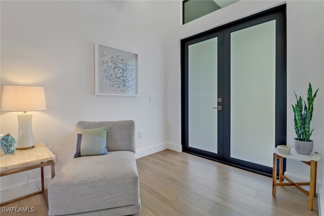 sitting room featuring light wood-type flooring and french doors