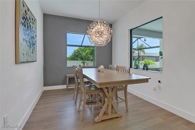 dining room with wood-type flooring and a notable chandelier