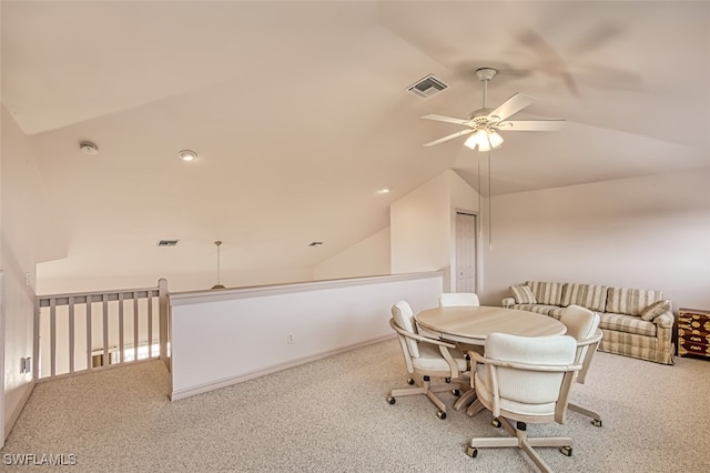 carpeted dining room with vaulted ceiling and ceiling fan