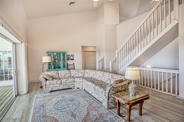 living room featuring high vaulted ceiling, ceiling fan, and light hardwood / wood-style floors