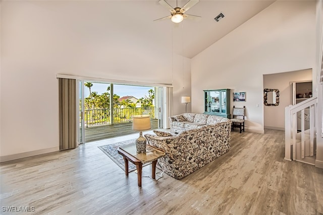 living room featuring light hardwood / wood-style floors, high vaulted ceiling, and ceiling fan