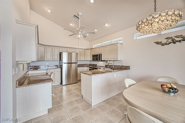 kitchen featuring stainless steel appliances, decorative light fixtures, light tile patterned floors, sink, and kitchen peninsula