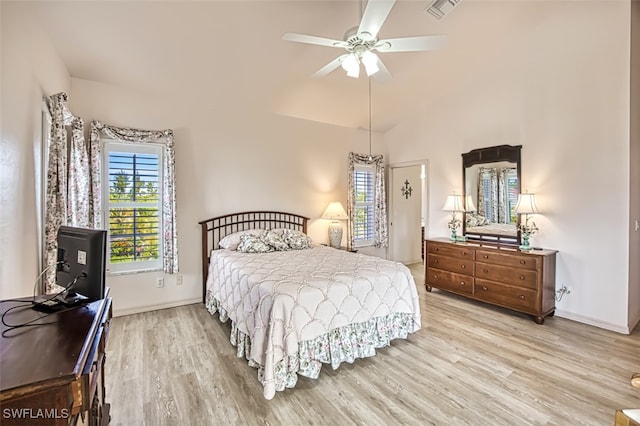 bedroom featuring multiple windows, vaulted ceiling, and light wood-type flooring