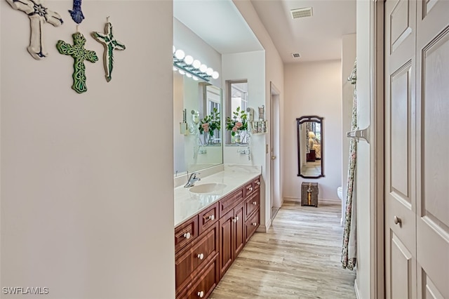 bathroom with hardwood / wood-style floors, toilet, and vanity