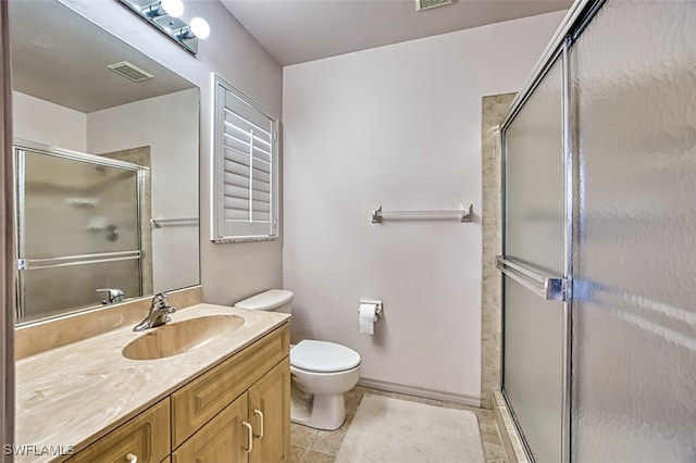 bathroom featuring toilet, a shower with door, and vanity