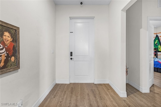 hallway with light hardwood / wood-style flooring