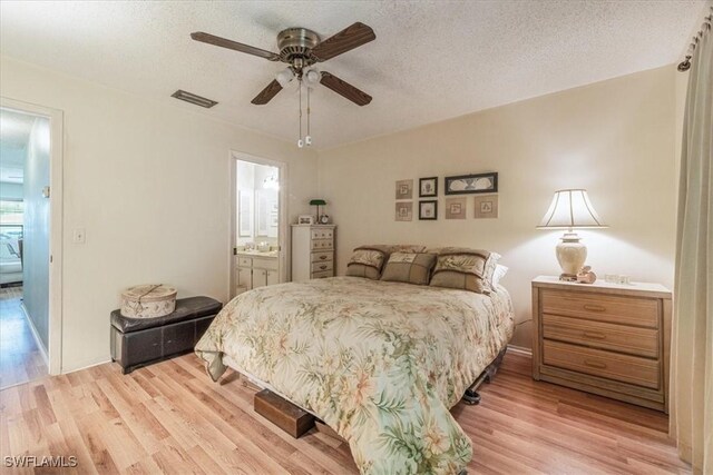 bedroom featuring ceiling fan, connected bathroom, a textured ceiling, and light hardwood / wood-style floors