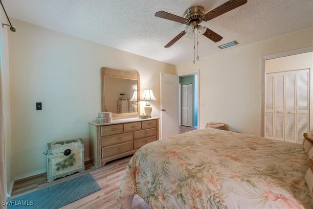 bedroom featuring ceiling fan, light wood-type flooring, a closet, and a textured ceiling