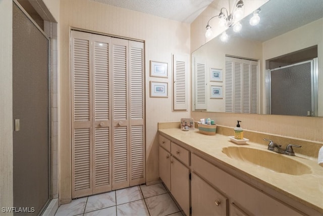 bathroom with tile patterned flooring, a textured ceiling, and vanity