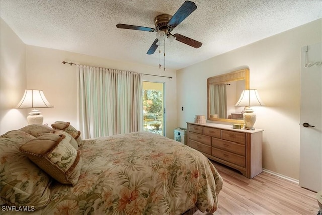 bedroom with ceiling fan, access to outside, light hardwood / wood-style flooring, and a textured ceiling