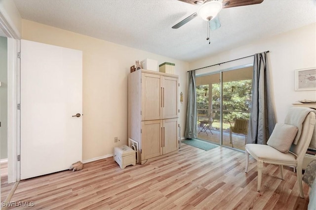 interior space featuring ceiling fan, light hardwood / wood-style flooring, and a textured ceiling