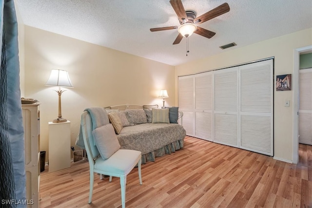 sitting room with ceiling fan, a textured ceiling, and light hardwood / wood-style flooring