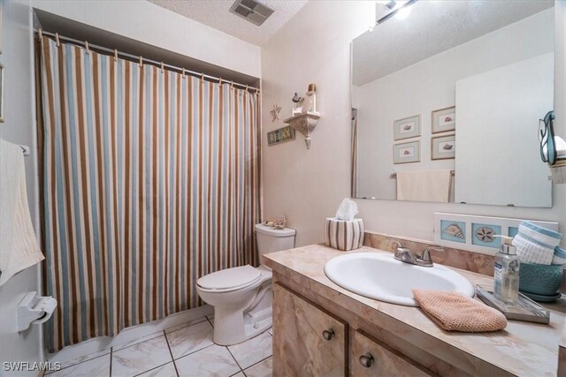 bathroom with tile patterned flooring, a textured ceiling, vanity, and toilet