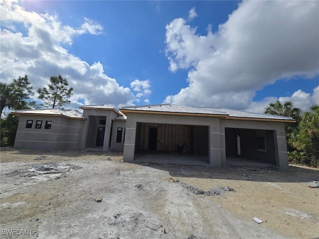 unfinished property featuring a garage and stucco siding