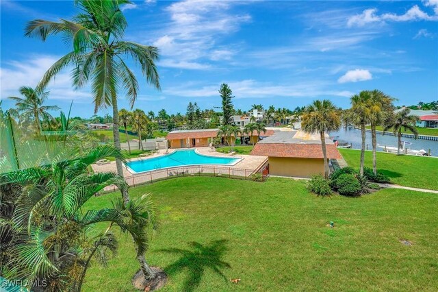 view of swimming pool featuring a water view and a yard