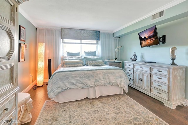 bedroom with hardwood / wood-style flooring and ornamental molding