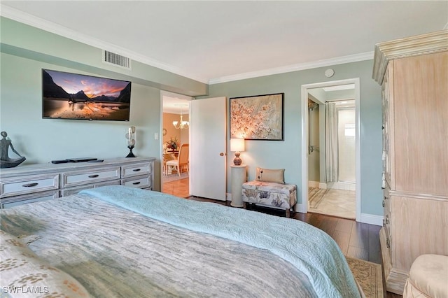 bedroom with crown molding, ensuite bath, dark hardwood / wood-style flooring, and a chandelier