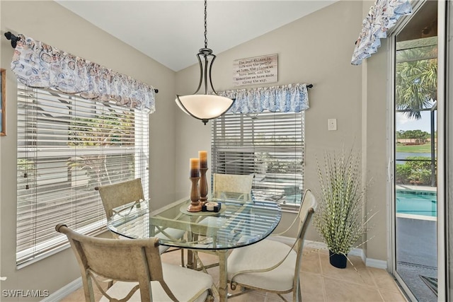 dining space featuring light tile patterned floors and vaulted ceiling