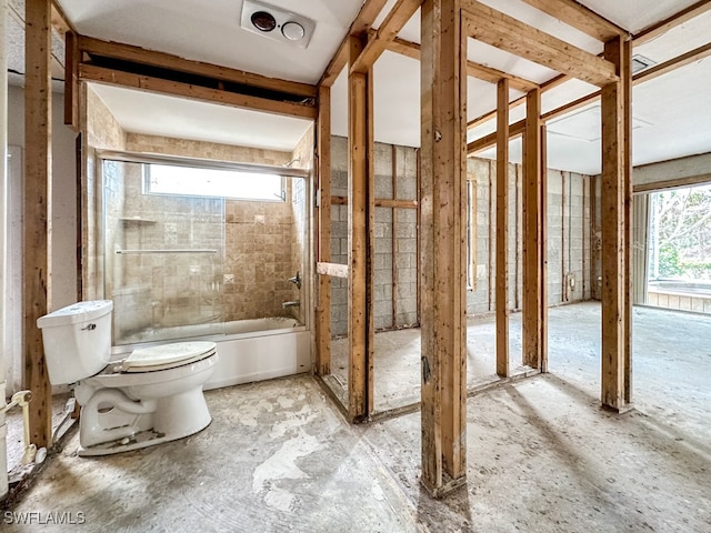 bathroom with enclosed tub / shower combo and toilet