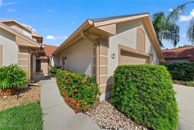 view of home's exterior with an attached garage and stucco siding